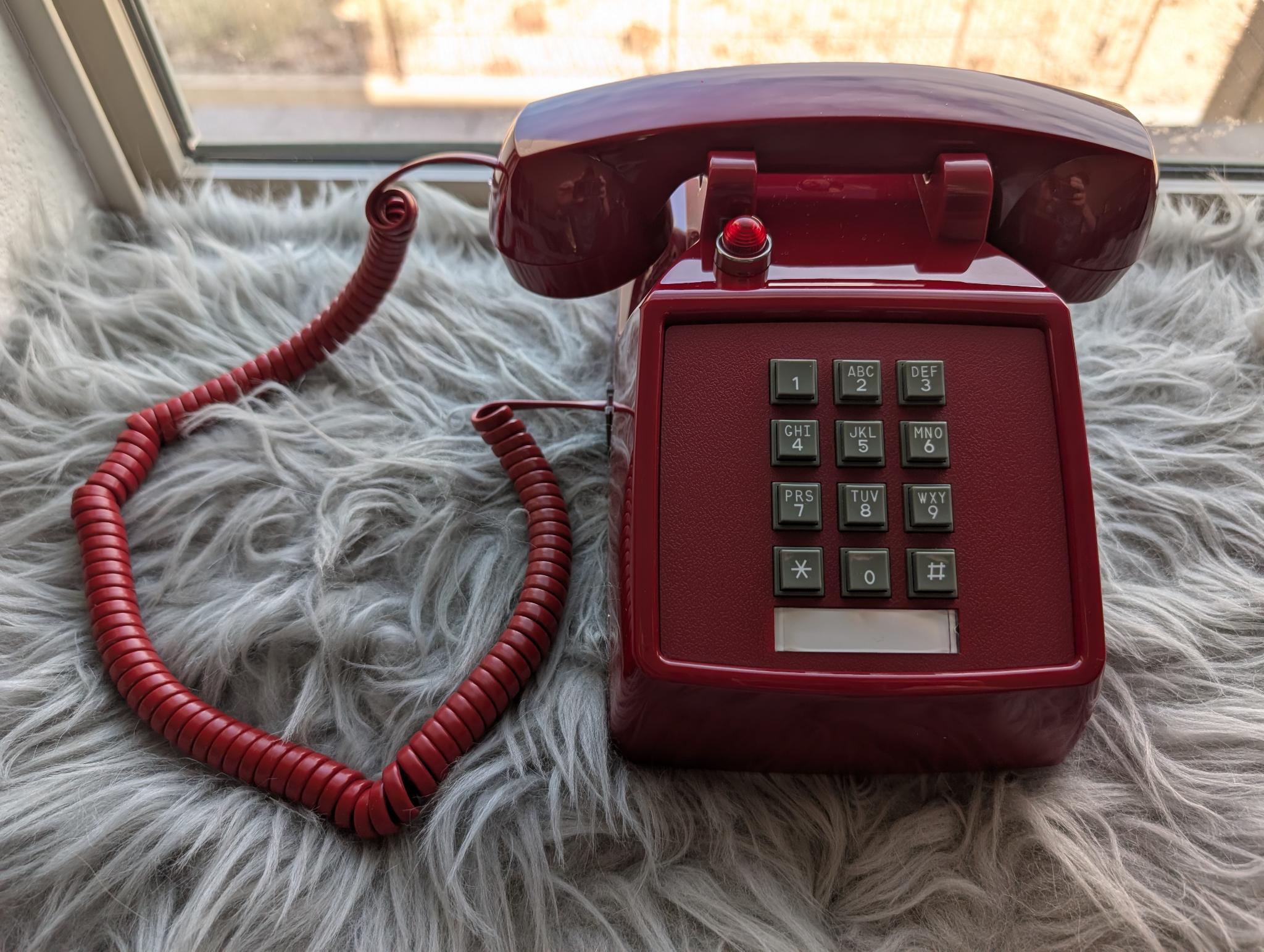 A cherry red touch-tone telephone